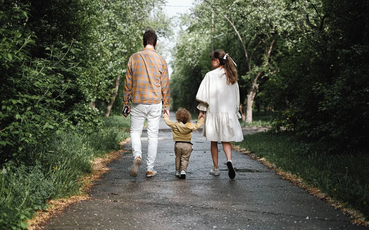 Ağaçlı yolda yürüyen bir aile